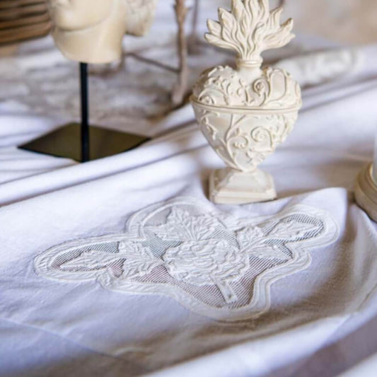 Tovaglia ricamata con gala Soffio Collection su un tavolo elegante con decorazioni raffinate.